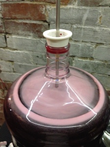 Using a drill mounted mix-stir to remove CO2 produced by fermentation from the wine.